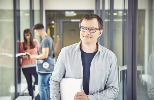 Ein lächelnder Mann sitzt auf einem Sessel und schaut sich Dokumente des KVS auf einem Tablet an.
