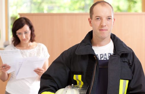 Ein Feuerwehrmann lächelt nach einem Beratungsgespräch zur Beihilfe in die Kamera.