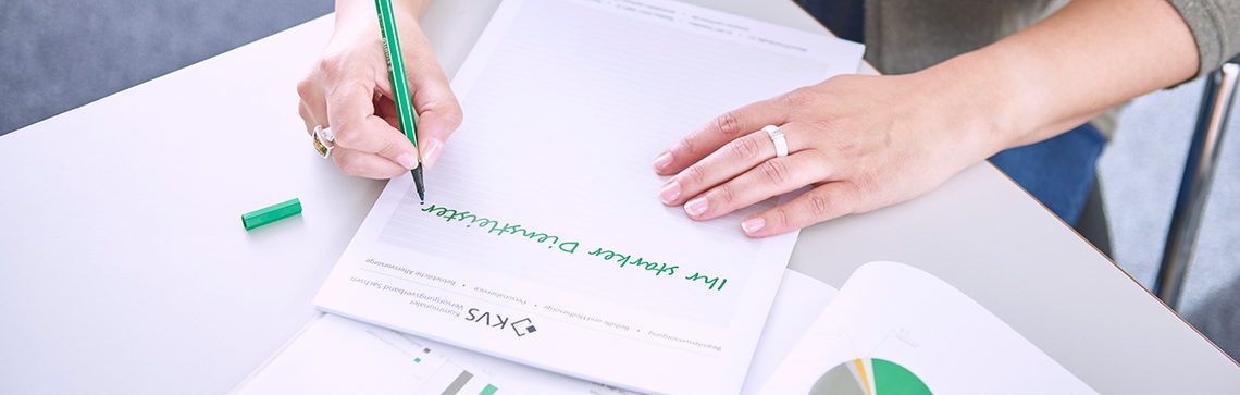 Foto einer Mitarbeiterin, die den Slogan des KVS aufschreibt